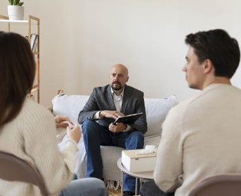 A couple speaking to a man
